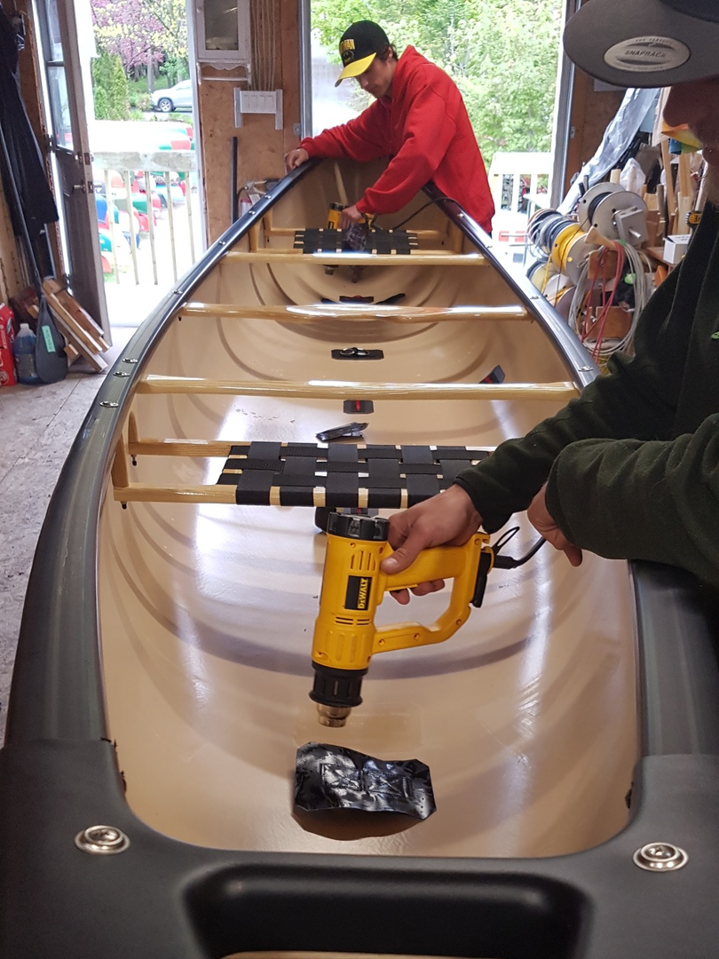 Collage des ancrages dans un canot dans l'atelier Canots Légaré Chauffage de la colle pour l'installation des ancrages dans un canot